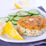 Lemon pepper salmon patties garnished with lemon and celery slices on a white plate