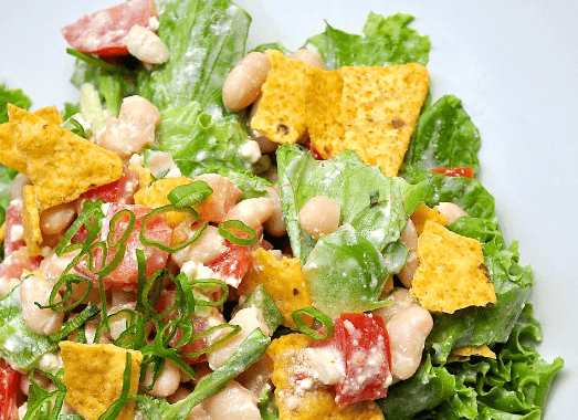 A closeup of a taco salad on a white background