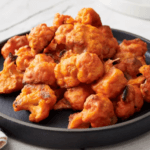 Buffalo cauliflower wings on a black plate