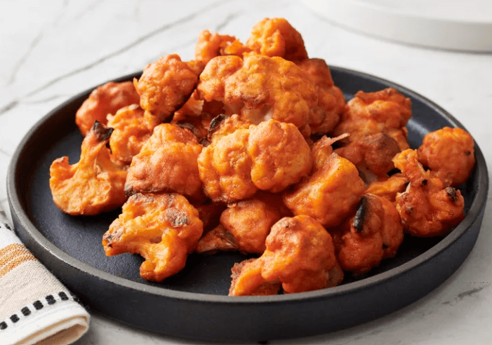 Buffalo cauliflower wings on a black plate