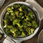 Roasted Broccoli in a bowl with utensils and napkin.