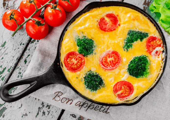 Broccoli tomato frittata in a cast iron pan