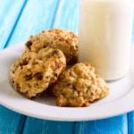 Applesauce cookies with raisins and a glass of milk.
