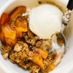 Peach crisp vanilla ice cream in a white bowl.