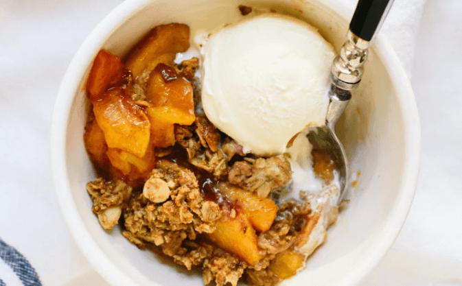 Peach crisp vanilla ice cream in a white bowl.