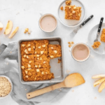 Apple baked oats in a baking dish surrounded by ingredients from the recipe