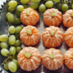 Oranges and grapes arranged as a pumpkin patch.