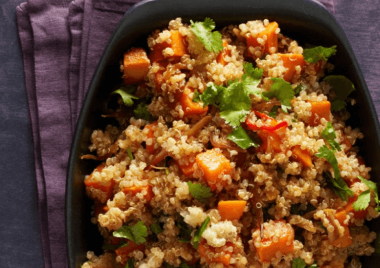 Spicy quinoa with sweet potatoes on a black plate