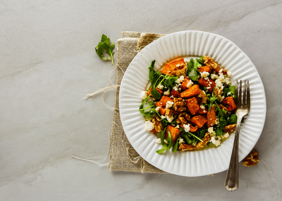Sweet potato and arugula salad on a white plate
