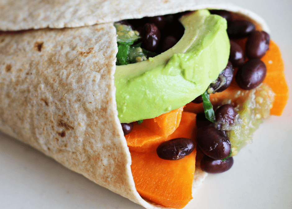 Closeup photo of a sweet potato and black burrito on a white surface