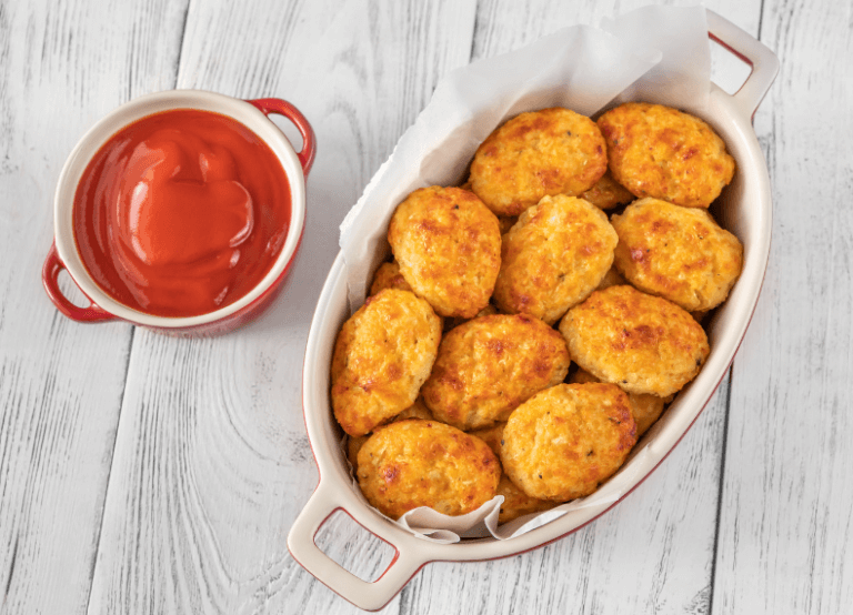 baked cauliflower tots in a dish with ketchup.