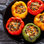 5 stuffed peppers in a cast iron pan