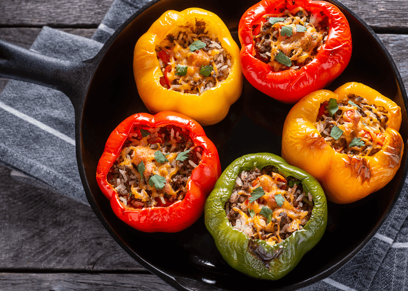 5 stuffed peppers in a cast iron pan