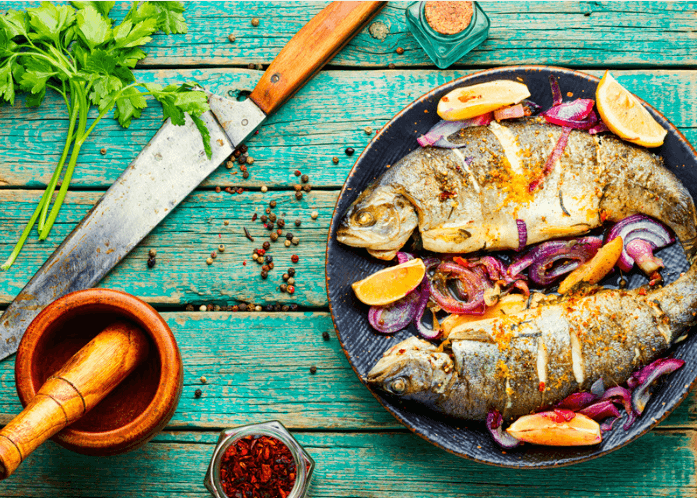 Baked trout on a plate with a knife