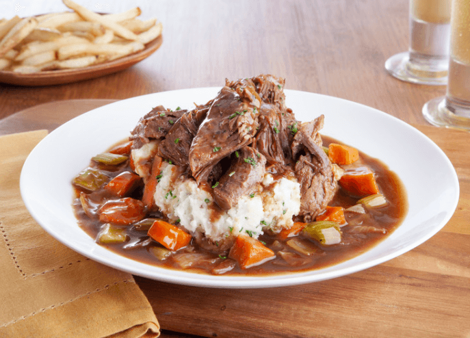 Beef pot roast on mashed potatoes with carrots