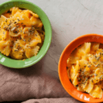 two bowls of pumpkin mac and cheese with herbs