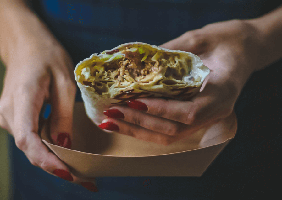 Tofu and broccoli wrap in hands