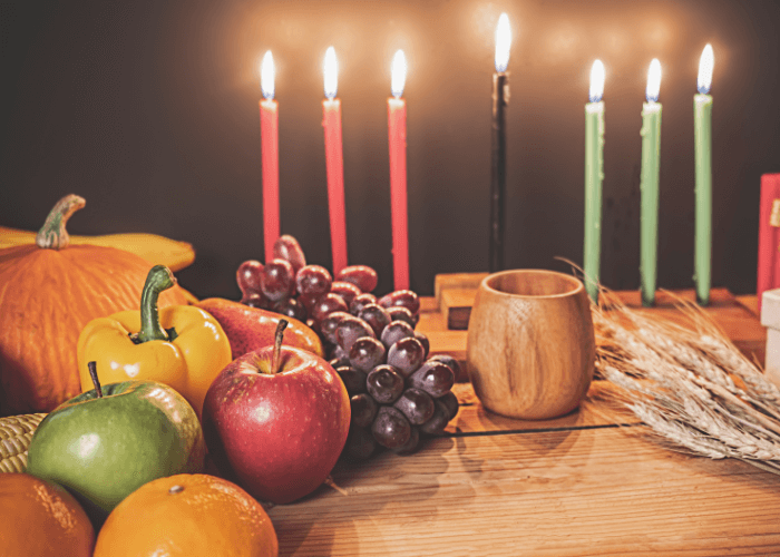 Lit candles with pumpkin, apples, peppers, wheat