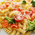 Rotini noodles with tomatoes broccoli and parmesan cheese
