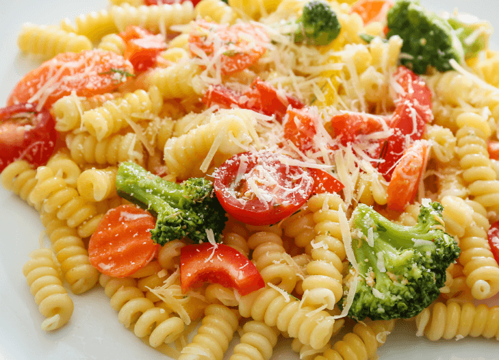 Rotini noodles with tomatoes broccoli and parmesan cheese