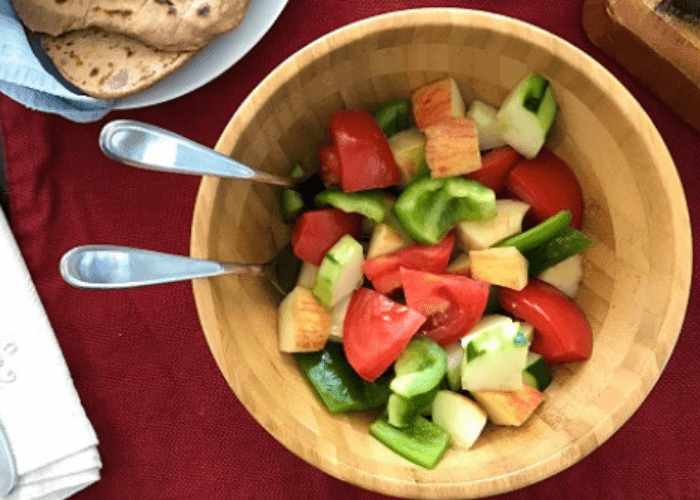 Summer salad with chopped peppers, tomatoes, cucumbers, and apples