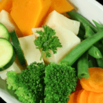 Dish with butter, broccoli, zucchini, carrots, green beans