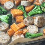 baking sheet with chopped sausage, broccoli florets, and diced sweet potato