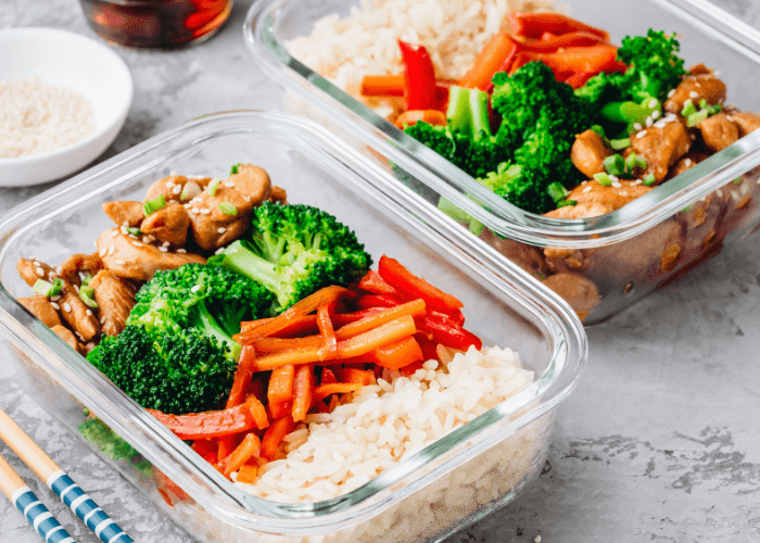 Meal prep containers with broccoli, carrots, chicken & rice