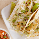 Tacos with white fish, lime, cheese, shredded cabbage
