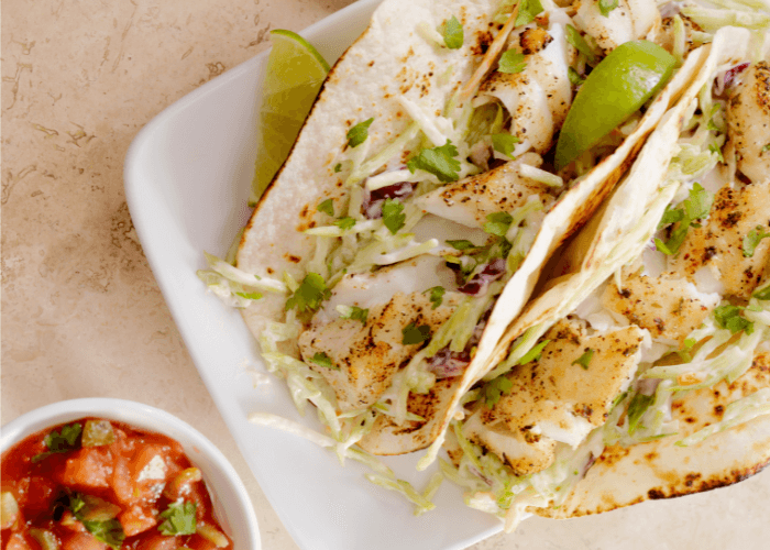 Tacos with white fish, lime, cheese, shredded cabbage