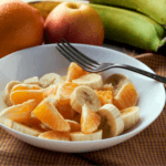 Fruit salad with apples, bananas, and oranges.