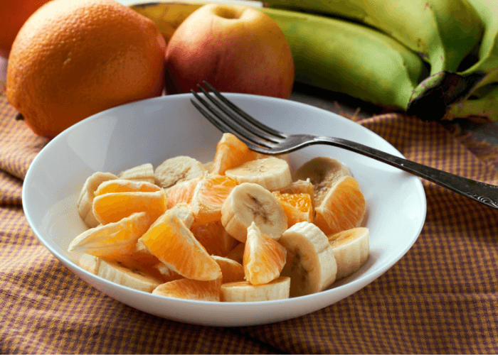 Fruit salad with apples, bananas, and oranges.