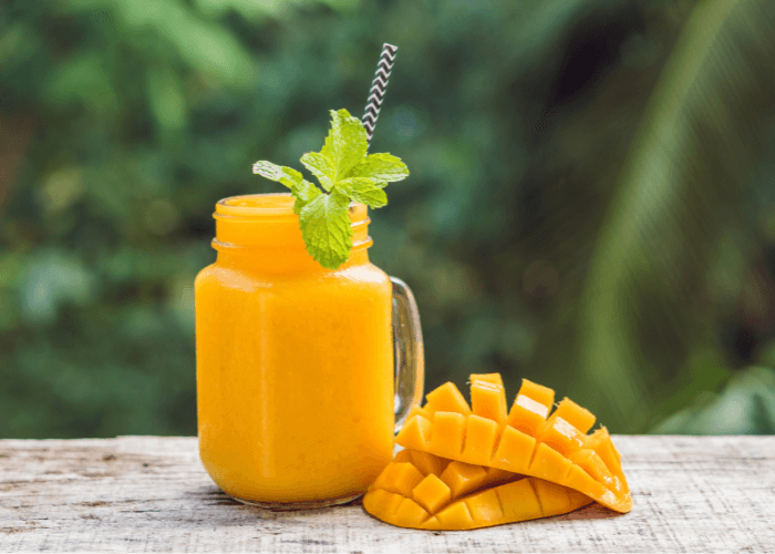 Smoothie with mangos and a halved mango