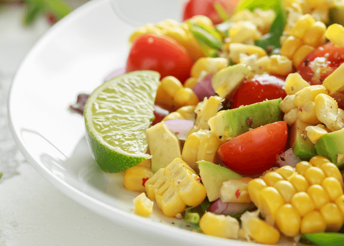 Summer salad with lime, avocado, corn, tomatoes