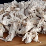 Slow Cooker Shredded Chicken on a wood cutting board