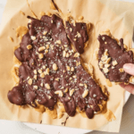 Peanut Butter Banana Bark with chopped peanuts on parchment paper
