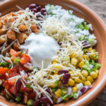 Chipotle Chicken bowl with cheese, guacamole, beans, peppers