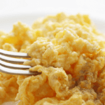 Fluffy scrambled eggs with a fork