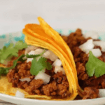 two Chorizo Street Tacos with onions on tortilla shells