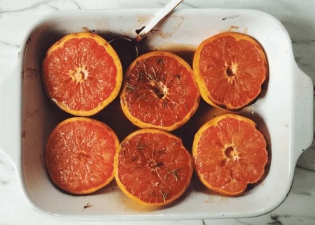 Halved grapefruits with seasoning in a baking dish