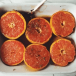 Halved grapefruits with seasoning in a baking dish