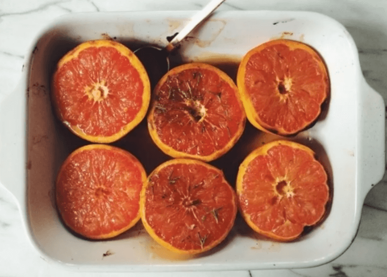 Halved grapefruits with seasoning in a baking dish