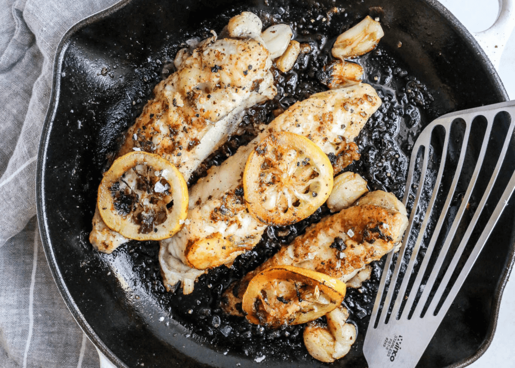 monkfish in a pan with lemon slices