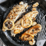 monkfish in a pan with lemon slices