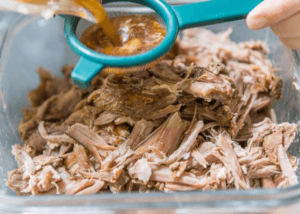 pulled pork in a dish and draining fat water
