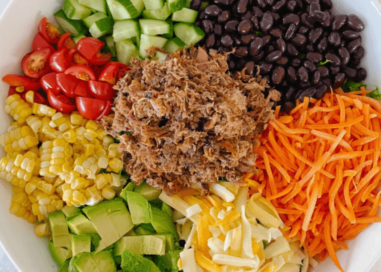 Pulled Pork Salad with tomatoes, cucumber, beans, carrots, avocado, and cheese
